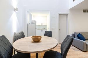 een eetkamer met een houten tafel en stoelen bij Segismundo FreshApartments by Bossh Apartments in Málaga
