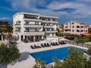 an apartment with a swimming pool and a building at Boutique Hotel IVY'Z in Novalja