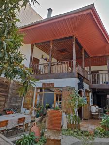 een huis met een balkon en een tafel en stoelen bij Helvacılar Konağı in Karacasu