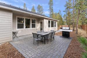 a patio with a table and chairs and a grill at 172 Avocet home in Sunriver