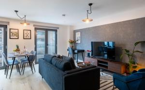 a living room with a blue couch and a table at Kula Manchester in Manchester