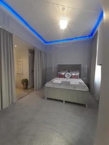 a bedroom with a bed with a blue led ceiling at Apartamenty "PRZY KATEDRZE" GORZÓW - jacuzzi in Gorzów Wielkopolski