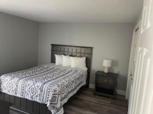 a bedroom with a bed and a table with a lamp at Seabreeze Motel in Old Orchard Beach