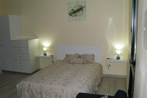 1 dormitorio con 1 cama y 2 luces en 2 mesas en Paradise Santo Amaro, en Ponta do Sol 4 fotos más