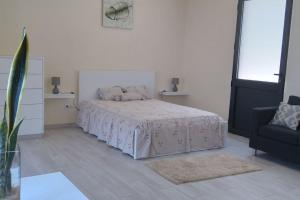 Un dormitorio blanco con una cama y una silla. en Paradise Santo Amaro, en Ponta do Sol
