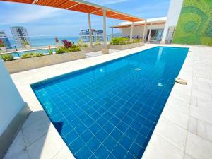 una piscina azul con vistas al océano en Apartamentos Salguero Suites - Cerca al Mar by SOHO, en Santa Marta