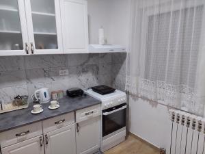 a kitchen with white cabinets and a stove top oven at DAN 9 in Sombor