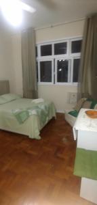 1 dormitorio con 2 camas y ventana grande en Studio Copacabana, en Río de Janeiro