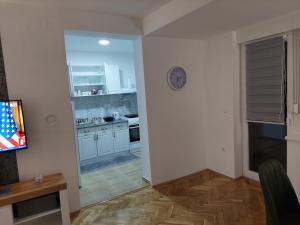 a kitchen with white cabinets and a clock on the wall at DAN 9 in Sombor