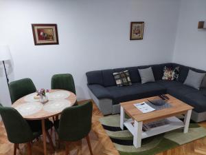 a living room with a couch and a table and chairs at DAN 9 in Sombor