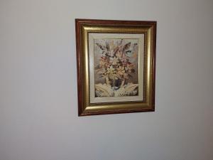 a framed picture of a vase of flowers on a wall at DAN 9 in Sombor
