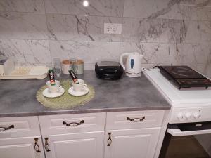a kitchen counter with two cups and a stove at DAN 9 in Sombor