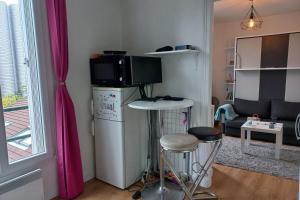 ein Wohnzimmer mit einer Mikrowelle auf dem Kühlschrank in der Unterkunft Cozy studio ideal for a romantic holiday in Montreuil