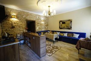 a living room with a blue couch and a table at Hotel Daisy S Home in Kutaisi