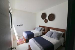 トゥルムにあるAmazing!! PH 2 Bdrm + Private Rooftop &Pool /Aldea Zamaのベッドルーム1室(ベッド2台、壁掛け時計付) +6枚の写真