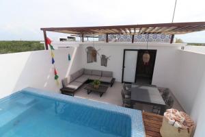 a house with a swimming pool next to a house at Amazing!! PH 2 Bdrm + Private Rooftop &Pool /Aldea Zama in Tulum