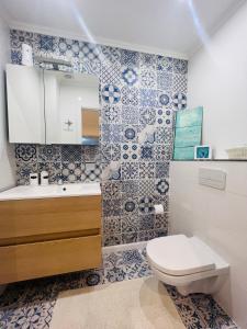 La salle de bains est pourvue de toilettes et d'un lavabo. dans l'établissement Windsor Residence Grimbergen, à Grimbergen