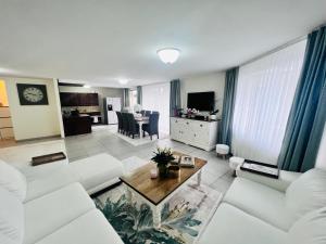 a living room with white couches and a table at Windsor Residence Grimbergen in Grimbergen