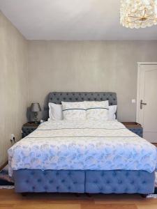 a bedroom with a large bed with a blue comforter at Windsor Residence Grimbergen in Grimbergen