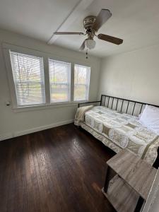1 dormitorio con 1 cama y ventilador de techo en The Little FarmHouse en Russell Springs