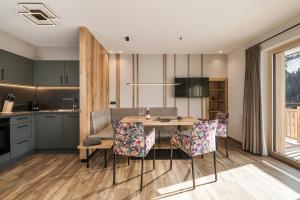 a kitchen and dining room with a table and chairs at Jagdhof PURE Mountain Appartements in Tux
