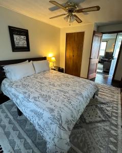 1 dormitorio con 1 cama y ventilador de techo en The Little FarmHouse en Russell Springs
