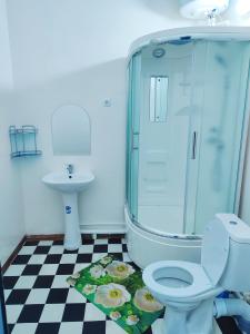 a bathroom with a shower and a toilet and a sink at World Guest House in Samarkand