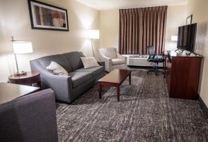 sala de estar con sofá y mesa en Cobblestone Hotel & Suites - Lamar, en Lamar