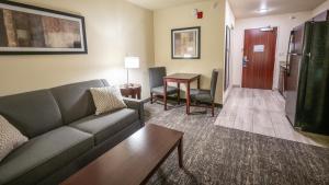 Lamar的住宿－Cobblestone Hotel & Suites - Lamar，客厅配有沙发和桌子