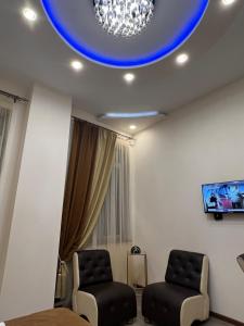 ein Wohnzimmer mit 2 Stühlen und einer blauen Decke in der Unterkunft Hotel Fleur Yerevan in Yerevan