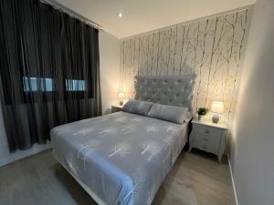 a bedroom with a bed and two night stands with lamps at Espectacular y céntrico piso in Cangas de Morrazo