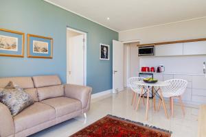 a living room with a couch and a table at The View, Apartment, with magnificent sea view in Hermanus