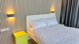 ein Schlafzimmer mit einem weißen Bett mit zwei Leuchten in der Unterkunft Wadi Shab Beach Villa in Sur