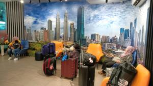 a group of people sitting in chairs with luggage at One Maxim Residence at Taragon in Kuala Lumpur