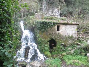a waterfall next to a building next to a river at Casa Velina in Castelnuovo Cilento