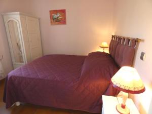 a bedroom with a purple bed with two lamps at Le clos fleuri in Liposthey
