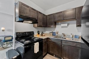 a kitchen with wooden cabinets and a black stove at Flexhome Marquette Economy 1BR MP8 - READ INFO in Milwaukee