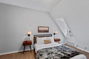 a white bedroom with a bed and two lamps at Flexhome Marquette Economy 1BR MP8 - READ INFO in Milwaukee