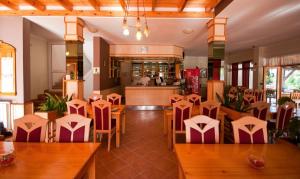 a restaurant with tables and chairs and a kitchen at Plitvicka Vrela in Grabovac