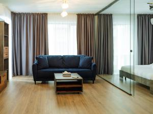 a living room with a blue couch and a bed at CloudView Studio - Aviatiei, Private Underground Parking in Bucharest