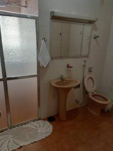 uma casa de banho com um chuveiro, um WC e um lavatório. em Apartamento Serra da Canastra com garagem em Piuí