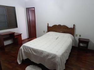 um quarto com uma cama, uma mesa e uma janela em Apartamento Serra da Canastra com garagem em Piuí