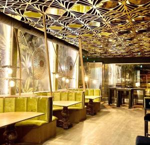 布尔戈斯Hotel Confort BRASEROS的有桌椅和天花板的餐厅