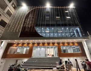 un edificio con escaleras y gente parada frente a él en Hotel Royal Palace Gaya en Gaya