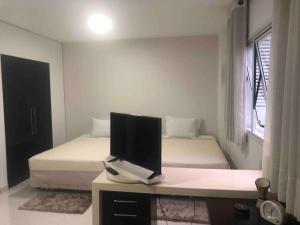 1 dormitorio con escritorio y monitor de ordenador en 902Ap em Alphaville maravilhoso en Barueri