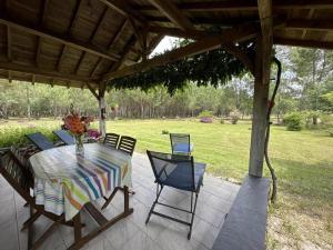 un patio con mesa y sillas bajo un pabellón en La grange, en Commensacq