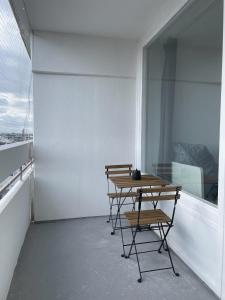 three chairs and a table in a room with a window at Cosy flat with stunning view in Offenbach