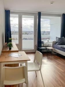オッフェンバッハにあるCosy flat with stunning viewのリビングルーム(テーブル、椅子、ソファ付)