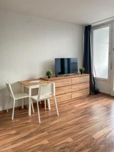 uma sala de jantar com uma mesa e uma televisão num armário em Cosy flat with stunning view em Offenbach