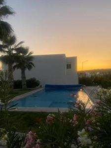 - une piscine en face d'une maison avec un coucher de soleil dans l'établissement A todo dar Querétaro Tres Cantos, à Tlacote el Bajo